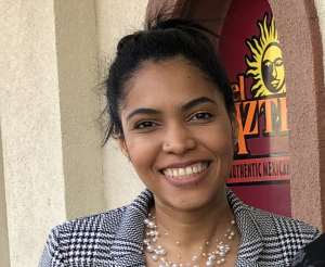 ILCM staff attorney Joyce Bennett Alvarado posing for the camera outside. A business logo can be partially seen in the background.